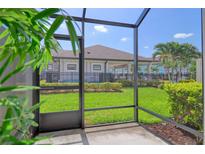 Covered and screened patio offers views of the backyard and a serene outdoor living space at 2487 Golden Pasture Cir, Clearwater, FL 33764
