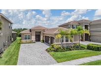 Beautiful single-Gathering home with a paver driveway, lush landscaping, and a two-car garage at 3197 Acacia Bay Ave, Wesley Chapel, FL 33543