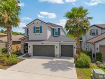 Inviting two-story home with three-car garage, and tropical landscaping under a sunny sky at 3532 Wicket Field Rd, Lutz, FL 33548