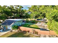 Aerial view of a well-maintained home with a fenced yard, lush greenery, and a covered parking area at 4901 Taylor N St, St Petersburg, FL 33714