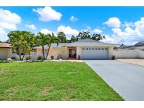 Charming single-story home with a well-maintained lawn and tropical landscaping at 5473 Bayshore Dr, Seminole, FL 33772