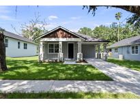 Charming single-story home features a well-manicured lawn and inviting covered front porch at 5707 N 20Th St, Tampa, FL 33610