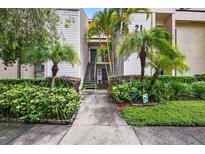 Charming condo featuring a well-kept exterior with lush landscaping and mature palm trees at 7821 Niagara Ave # 2102, Tampa, FL 33617