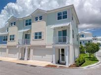 Charming townhome with pale green siding, white trim, balcony, and garage at 803 Oak Bend Ln, Dunedin, FL 34698