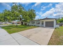 Charming single-story home featuring a well-manicured lawn and a long driveway leading to the attached garage at 8501 56Th N St, Pinellas Park, FL 33781