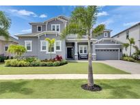 Beautiful two-story home showcasing a well-manicured lawn and lush landscaping, complete with palm trees at 978 Signet Dr, Apollo Beach, FL 33572