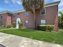 Charming red brick building with well-maintained lawn and landscape, creating a welcoming curb appeal at 1125 83Rd N Ave # D, St Petersburg, FL 33702