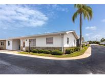 Charming single-story home with a manicured lawn and a beautiful palm tree in a sunny neighborhood at 12400 Park Blvd # 417, Seminole, FL 33772