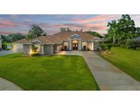 Beautiful home exterior with a long driveway, lush green lawn, and well-manicured landscaping at 1313 Oxbridge Dr, Lutz, FL 33549