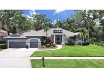 Beautiful single-story home featuring a well-manicured lawn, attached garage, and a welcoming front entrance at 15024 Eaglepark Pl, Lithia, FL 33547