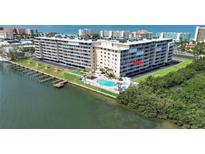 An aerial view of a waterfront condo complex with a pool and boat docks and access to the bay at 19451 Gulf Blvd # 205, Indian Shores, FL 33785