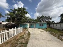 Charming single-story home featuring a light blue exterior, white trim, and a concrete driveway at 2175 20Th Sw Ave, Largo, FL 33774