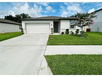 Charming single-story home with a well-manicured lawn, and a two car garage at 219 Lovely Ct, Plant City, FL 33566