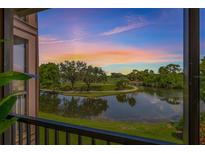 Scenic balcony view overlooking a lake and golf course at sunset with vibrant sky at 2400 Feather Sound Dr # 528, Clearwater, FL 33762