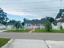 Charming single-story home featuring a white picket fence and well-maintained landscaping at 2610 W Powhatan Ave, Tampa, FL 33614