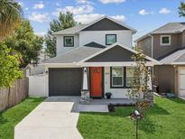 Charming two-story home with a well-manicured lawn and inviting orange front door at 2809 N 21St St, Tampa, FL 33605