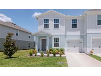 Charming two-story townhome featuring a one car garage and manicured landscaping at 3062 Victoria Inlet Dr, Holiday, FL 34691