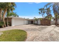 Stunning single-story home with a two-car garage, beautiful paver driveway, and lush tropical landscaping at 3830 46Th S Ave, St Petersburg, FL 33711