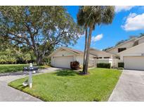 Inviting single-story home featuring a well-maintained lawn, mature trees, and attached garage at 440 Lakeview Dr # 34, Palm Harbor, FL 34683