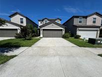 Charming two-story home with landscaped front yard and spacious driveway leading to a two car garage at 4448 Globe Thistle, Tampa, FL 33619
