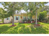 Charming home with a well-manicured front yard, featuring lush green grass and mature trees at 630 Mac Crillus Rd, Largo, FL 33770