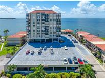 Coastal condominium complex with a parking garage against a blue sky and water backdrop at 6372 Palma Del Mar S Blvd # 601, St Petersburg, FL 33715