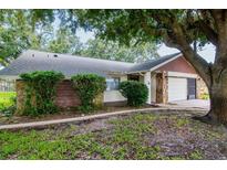 Charming single-story home showcasing stone and wood accents plus lush landscaping enhancing its curb appeal at 8626 Woodbridge Dr, New Port Richey, FL 34655
