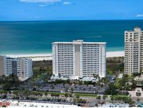 Stunning aerial view of beachfront condos with manicured grounds and ample parking at 1230 Gulf Blvd # 304, Clearwater, FL 33767