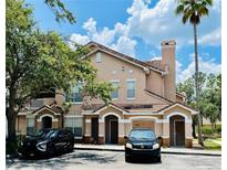 Charming condo with tan exterior, tile roof, and front parking on a sunny day at 17942 Villa Creek Dr # 17942, Tampa, FL 33647