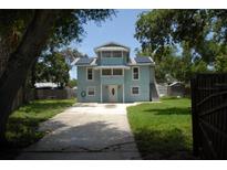 Charming two-story home with a bright blue exterior, solar panels, and a well-maintained front yard at 2321 Trelain S Dr, St Petersburg, FL 33712