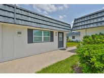 Inviting condo exterior features a private entrance, well-maintained landscaping and covered roof at 301 Kings Blvd # 130, Sun City Center, FL 33573