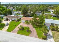 Aerial view of a single-Gathering home featuring a brick driveway, well-manicured lawn, and mature trees at 5262 25Th N Ave, St Petersburg, FL 33710
