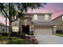 Two-story home featuring a front-facing two car garage and neutral color palette at 5916 Tulip Flower Dr, Riverview, FL 33578