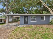 Charming single story home with gray exterior, front carport and mature trees at 705 3Rd Ne Ave, Largo, FL 33770