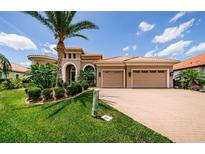 Beautiful Mediterranean home featuring a two-car garage, manicured landscaping, and a brick-paved driveway at 1012 Tuscany Dr, Trinity, FL 34655