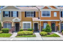 Charming townhome with colorful facade, well-maintained landscaping, and inviting entrances at 12464 Berkeley Square Dr, Tampa, FL 33626