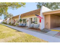 Inviting single-story villa featuring a charming front patio and an American flag for added curb appeal at 1371 Mission Hills Blvd, Clearwater, FL 33759