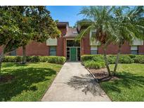 Inviting front entrance with a well-maintained lawn and lush tropical landscaping at 214 Caryl Way, Oldsmar, FL 34677