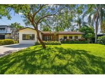 Charming home featuring a beautiful lawn, mature trees, and meticulously maintained landscaping at 4522 S Hale Ave, Tampa, FL 33611