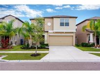 Two-story home with a two-car garage, well-manicured lawn, and fresh landscaping at 7017 Gomez Rocks Ct, Sun City Center, FL 33573