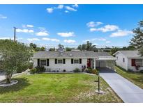 Charming single story home featuring a well-manicured lawn and a covered carport at 913 Augusta Dr, Sun City Center, FL 33573