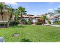 Charming single-story home featuring a well-manicured lawn and mature palm tree landscaping at 10880 Cory Lake Dr, Tampa, FL 33647