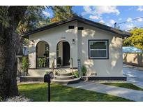 Charming single-story home featuring an arched entryway, fresh landscaping, and inviting curb appeal at 1206 E Osborne Ave, Tampa, FL 33603