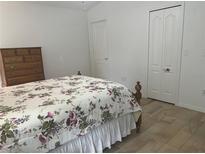 This bedroom features neutral paint, wood-look floors, and a large closet for ample storage at 15421 Shoal Haven Pl, Ruskin, FL 33573