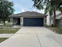 Charming single-story home featuring a two-car garage, well-maintained landscaping, and a welcoming entrance at 15421 Shoal Haven Pl, Ruskin, FL 33573