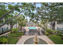 Beautiful pool area surrounded by mature trees, lounge chairs and a clubhouse at this wonderful community at 4325 Aegean Dr # 250B, Tampa, FL 33611