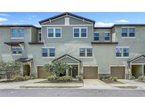 Charming townhome exterior featuring a two-car garage, stone accents, and well-maintained landscaping at 4567 Tuscan Loon Dr, Tampa, FL 33619
