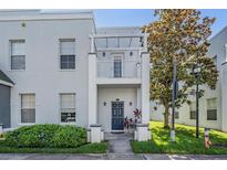 Charming townhome featuring a private balcony, front door entry, manicured lawn, and easy-to-access sidewalk at 5528 Liberty Plain Cir, Tampa, FL 33611
