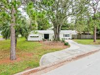Charming single-story home with a well-manicured lawn, mature trees, and a winding driveway at 5625 Atlantic N Ave, St Petersburg, FL 33703