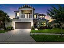 Charming two-story home featuring a balcony, manicured lawn, and a two-car garage at 8019 Marbella Creek Ave, Tampa, FL 33625